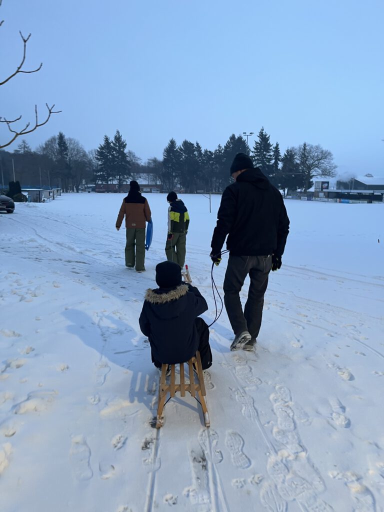 Familie im Schnee mit dem Schlitten hat man immer Spaß